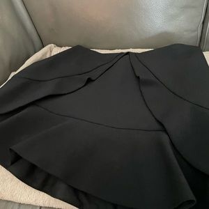 BCBG black short skirt . runs small . polyester and spandex . fully lined .